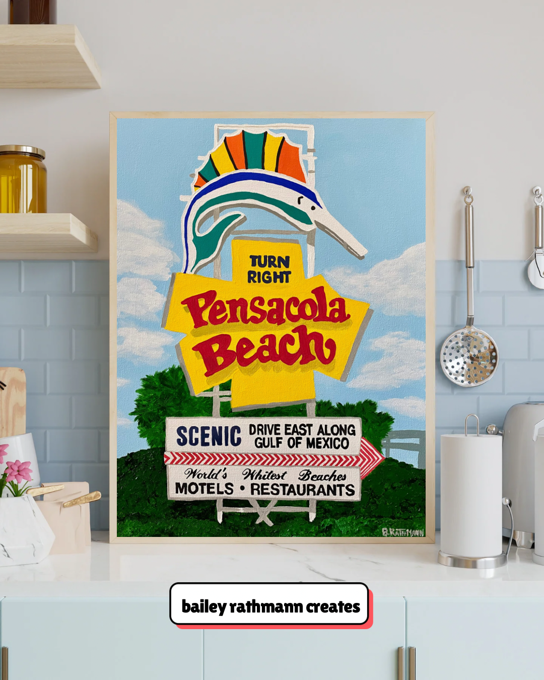 Framed art print of the Pensacola Beach, Florida welcome sign of a vintage-style road sign for Pensacola Beach on a kitchen counter.