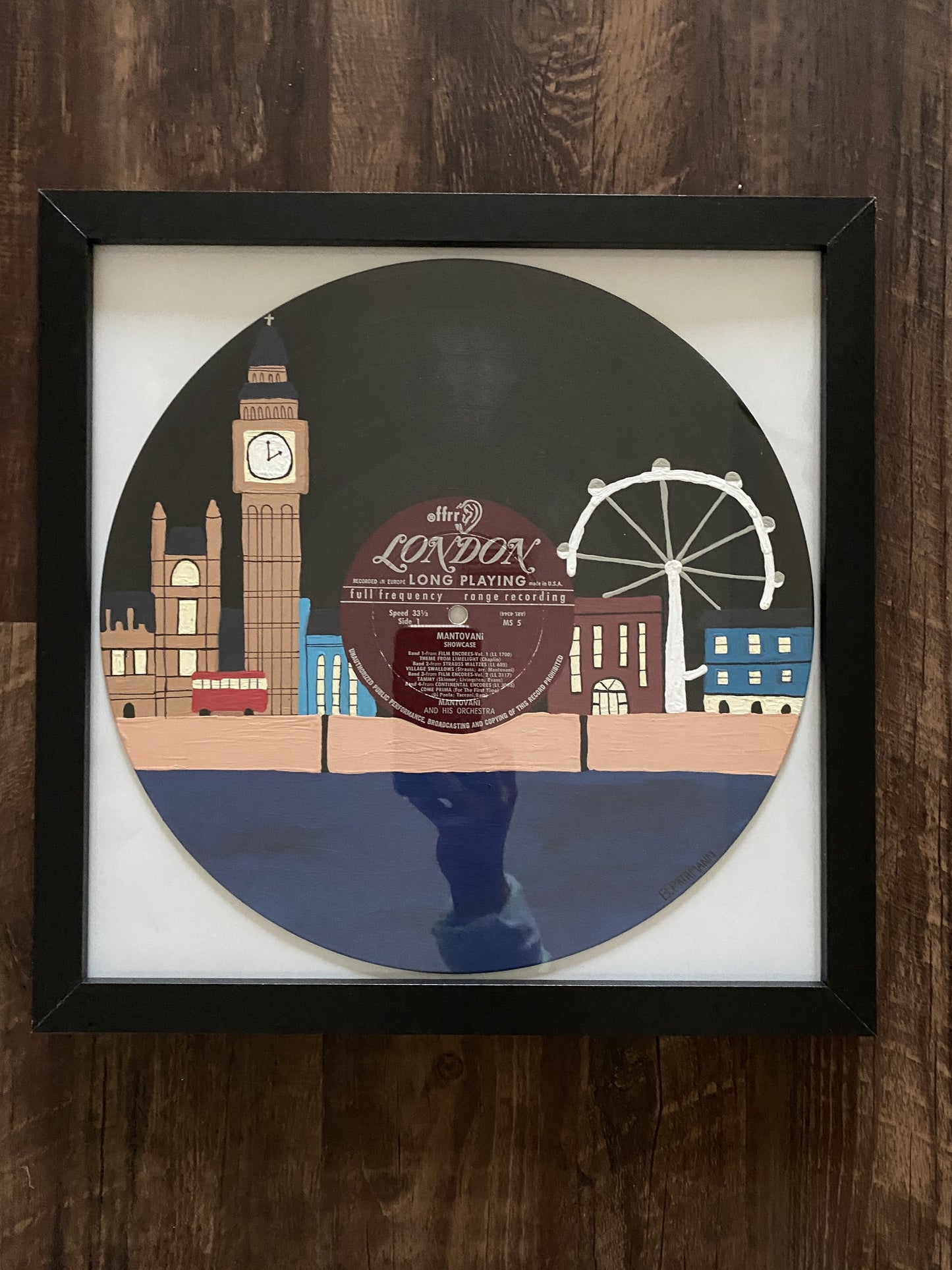 London Calling Record is an acrylic painting of some of the most iconic scenes in London including Big Ben, London Eye, the double-decker bus, and much more.